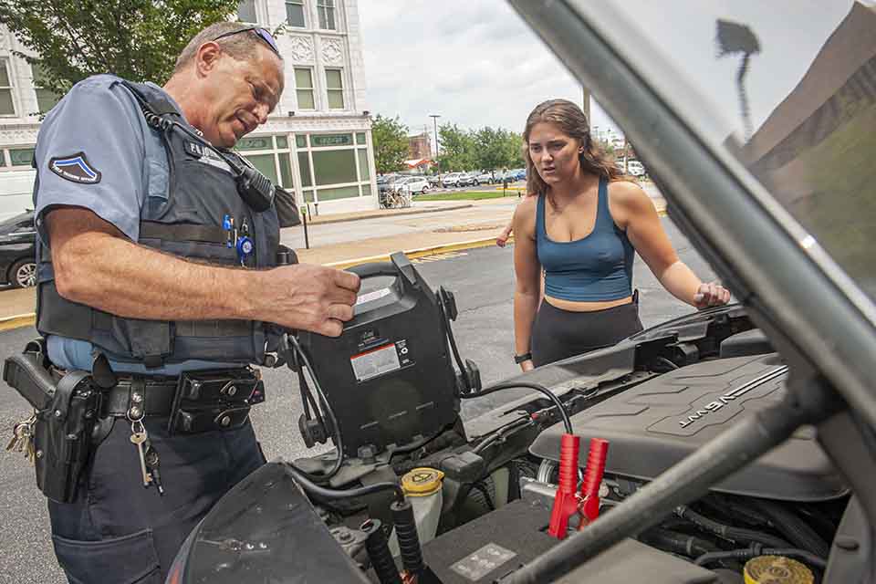 Vehicle assistance DPS officer helping a student with a jump start