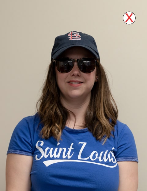 A headshot of a woman wearing a SLU t-shirt. She is wearing a baseball cap and dark colored sunglasses.