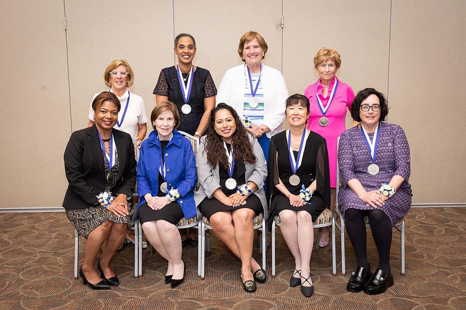 2025 Alumni Merit Awardees A group of nine alumni merit awardees pose for a photo together.