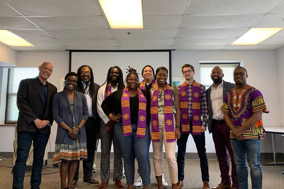 African American Studies Members of the African American Studies department smile while standing at the front of a classroom.