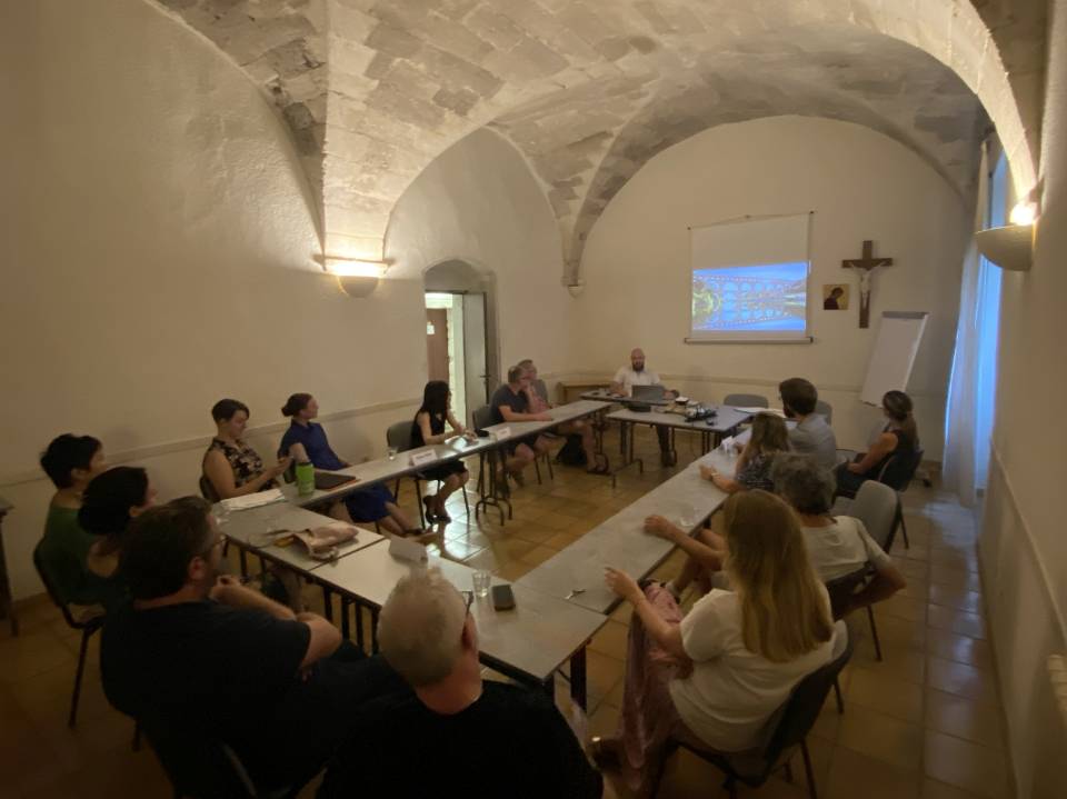 Archdiocese of Saint Louis Conference attendees sit in a room with arched ceilings, looking at a video screen.