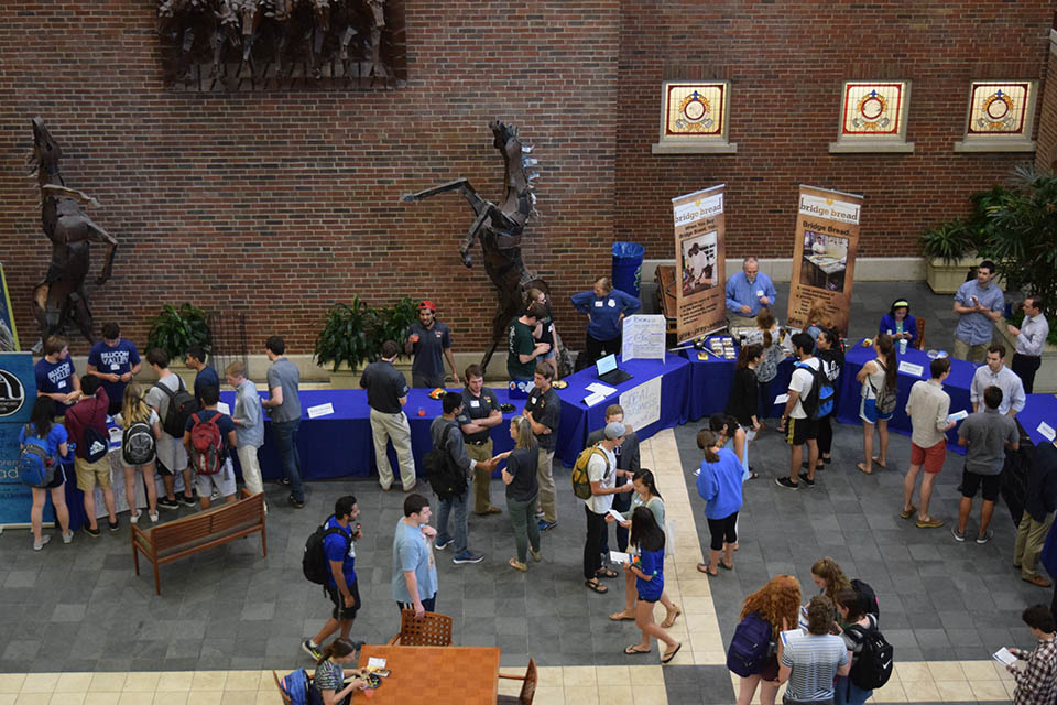Entrepreneurs at SLU Students are shown from above as they mill about informational tables.