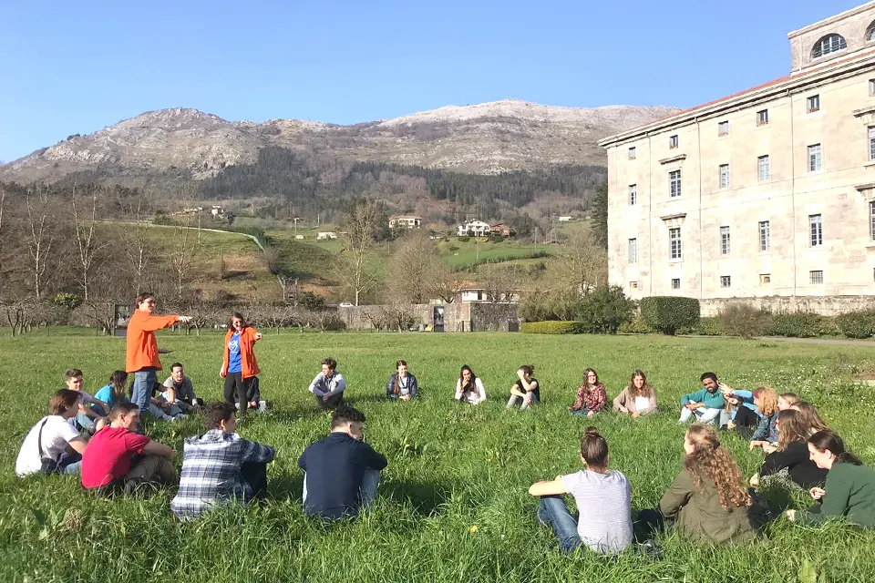 Mission Students sit in a circle in a field.