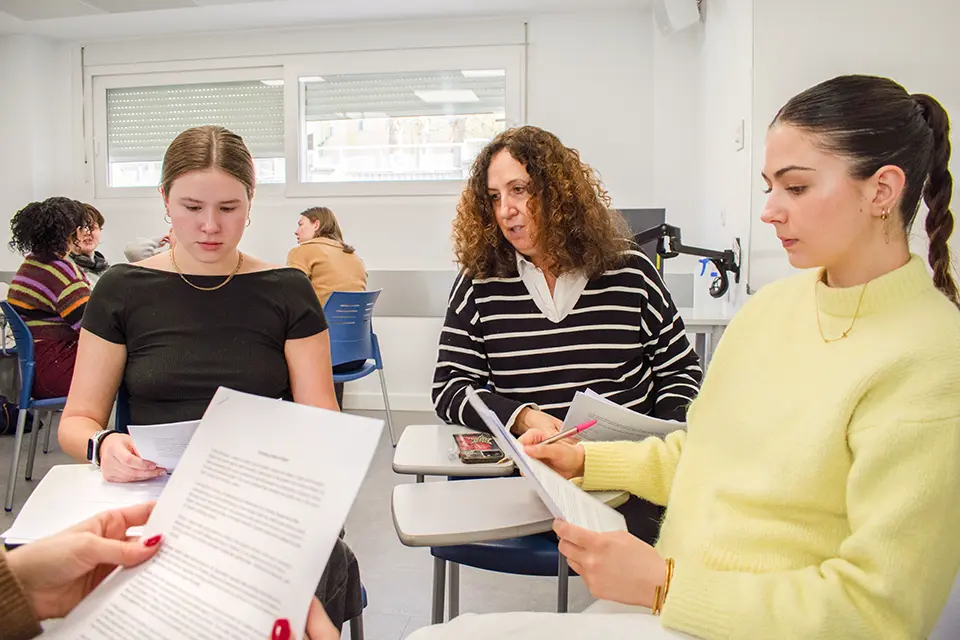 Students with professor looking at his laptop. Students with professor looking at his laptop.