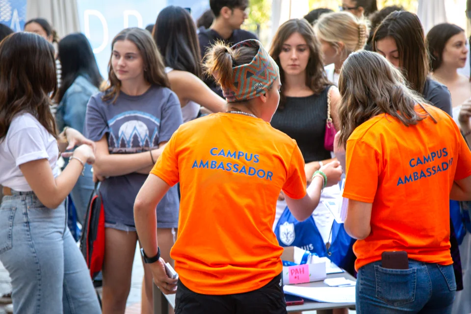 A large group of campus ambassador students pose outdoors on the SLU madrid campus. 