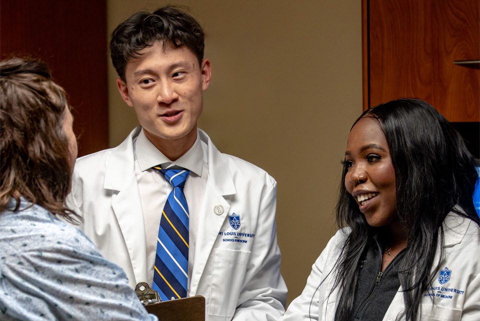 Two students talking with a standardized patient at the clinical skills center Two students talking with a standardized patient at the clinical skills center