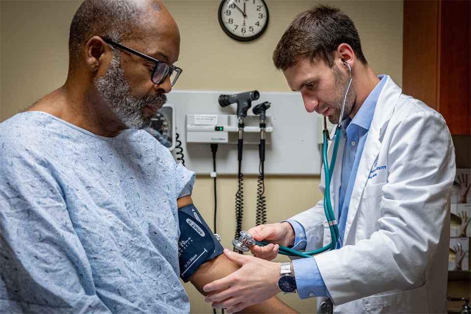 A student giving care in a simulated setting with a standardized patient A student giving care in a simulated setting with a standardized patient