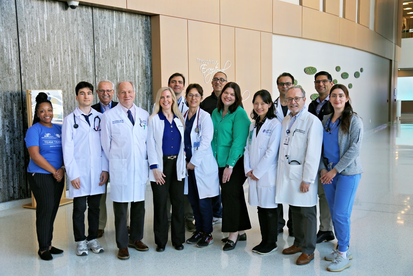 Division of Nephrology and Hypertension Department faculty pose for a group photo in the hallway of a SLU School of Medicine building.