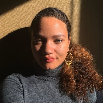 Summer Sloane-Britt Artist-curator Summer Sloane-Britt is dramatically illuminated by sunlight coming from the right side of this this close-up portrait.