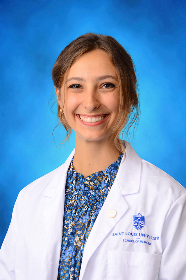Paige Colbert poses for a headshot against a blue background.