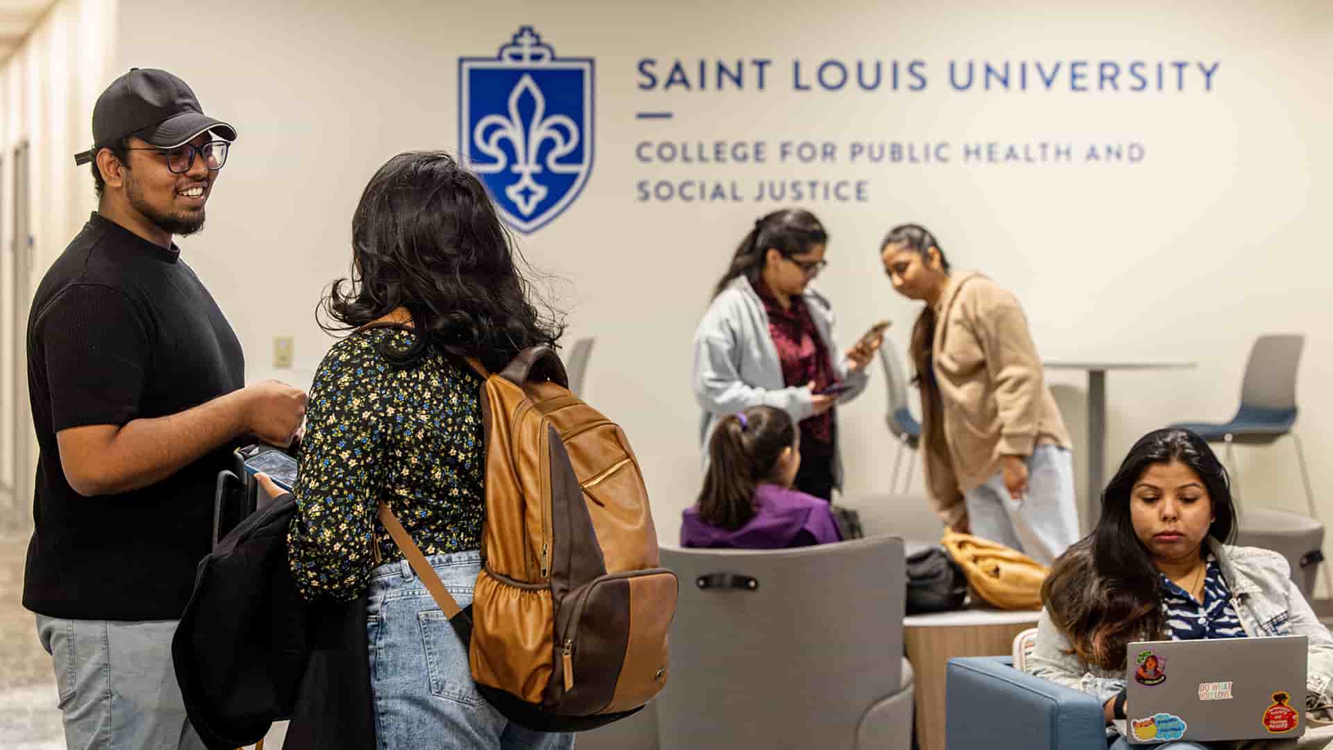 Students interact in groups in between classes in the main lobby space.