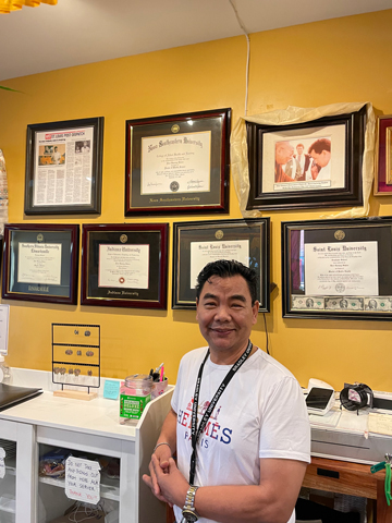 Devi States Devi States, PhD, DHSc, MPH, MSW, MS poses with his degrees that are proudly displayed on the wall at Everest Cafe.